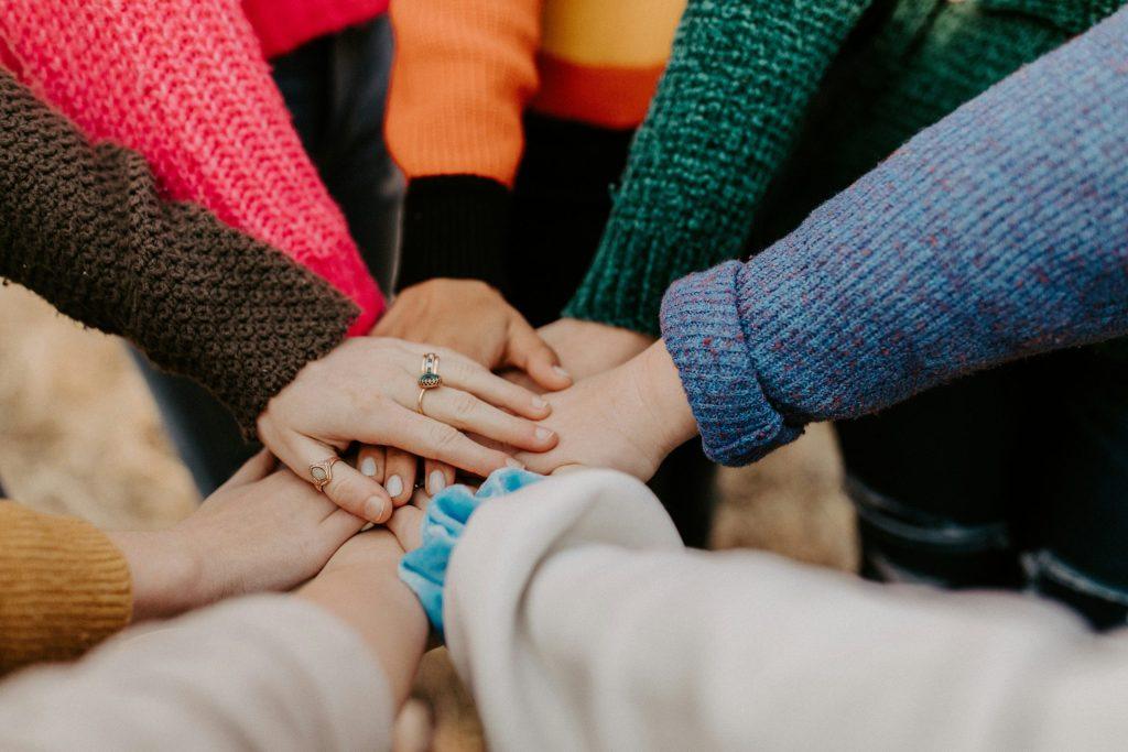 Teamwork hands joined together, symbolizing collaborative analytics and digital transformation in public sector IT consulting.